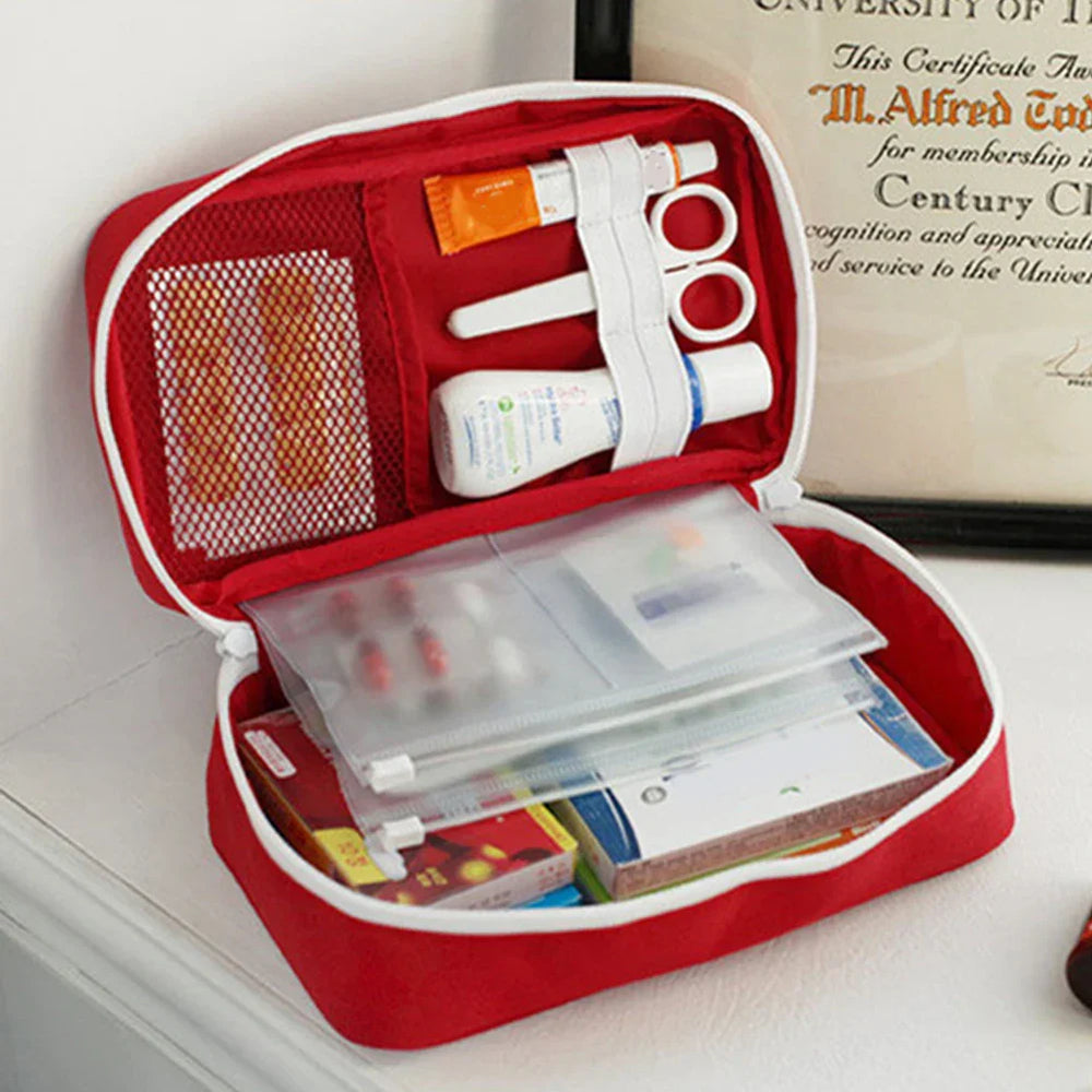 
                  
                    Portable emergency medical first aid kit with scissors, ointments, and bandages in a red pouch.
                  
                