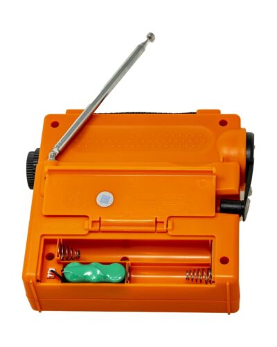
                  
                    Orange Tecsun GR-98 emergency radio with hand crank and battery compartment.
                  
                